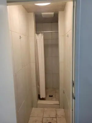 a shower with a shower curtain in a bathroom at Randolph Hotel in Huntington Park