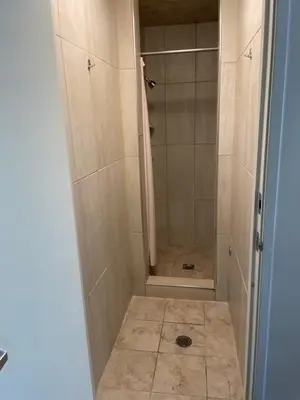 a shower with a glass door in a bathroom at Randolph Hotel in Huntington Park