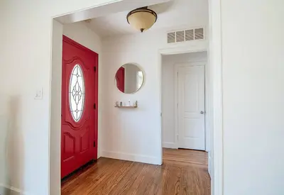 a red door in a white room with wooden floors at 3-Bedroom Sherman Oaks House Near Universal Studios in Los Angeles