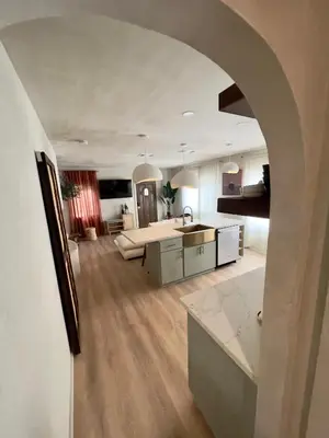 an open kitchen and living room with an archway at 2 Bedroom Tulum Oasis in Hollywood in Los Angeles