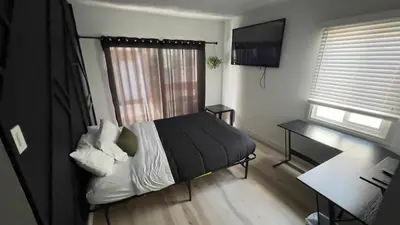a bedroom with a bed and a desk and a window at 2BR Lit and Spacious in the Heart of Hollywood in Los Angeles