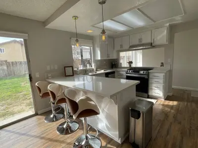 a kitchen with a large white counter and stools at Pristine & Smart freshly remodeled house! in Lancaster