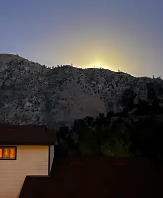 a house in front of a mountain at sunset at Mountain View Home in Kernville