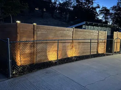 a fence with lights on it next to a sidewalk at Mountain View Home in Kernville