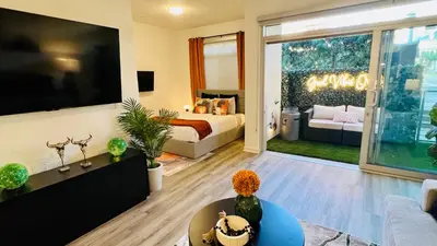 a living room with a bed and a large television at Luxury Open BD w Pool, Parking, & WD 133 in Los Angeles