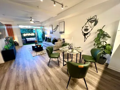 a living room with a table and green chairs at Luxury Open BD w Pool, Parking, & WD 133 in Los Angeles