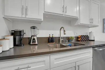 a kitchen with white cabinets and a sink at 6th Haven, Arcade, King Bed, Games, 1 Mile to Beaches in Long Beach