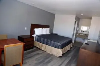 a hotel room with a bed and a desk at Grand Park Inn in Baldwin Park