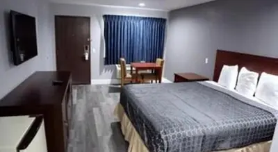 a hotel room with a bed and a table at Grand Park Inn in Baldwin Park