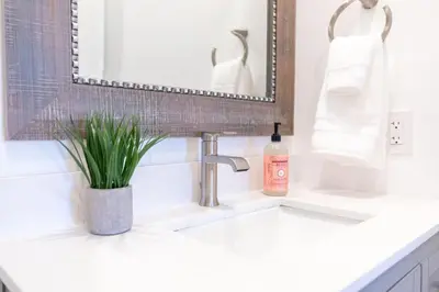 a bathroom sink with a bottle of soap and a mirror at Comfy and Stylish 4 Bathrooms 26 in Ridgecrest