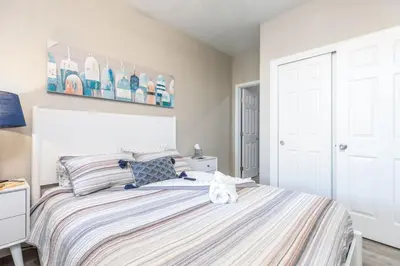 a white cat sitting on a bed in a bedroom at Luxury, Style and Comfort 4 Bathrooms 21 in Ridgecrest