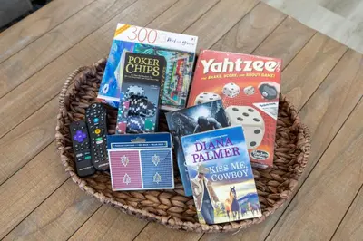 a basket filled with games and books on a table at Refreshing and Spotless 4 Bathrooms 22 in Ridgecrest