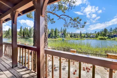 a deck with a view of a lake and trees at Breezy estate #114 in Big Bear Lake