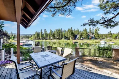 a table and chairs on a deck with a view of a lake at Breezy estate #114 in Big Bear Lake