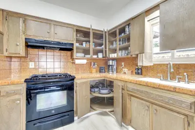 a kitchen with wooden cabinets and a black stove at Pet-Friendly Ridgecrest Home Near OHV Trails! in Ridgecrest