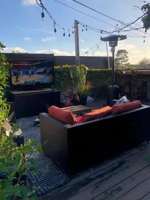 a couch with pillows on a patio with a tv at Inglewood Forum and Sofi park and walk private room in Inglewood