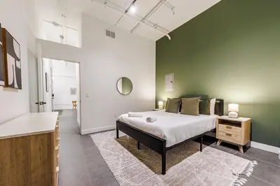 a bedroom with a bed and a green wall at Downtown Escape - 2BR w Skyline Views & Hot Tub in Los Angeles