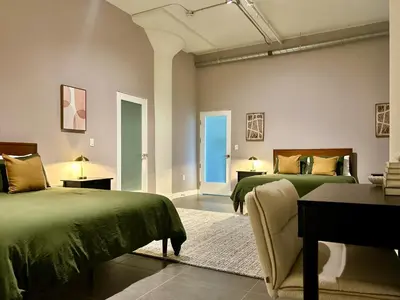 a bedroom with two green beds and a table at Luxury 2BR in DTLA w Jacuzzi & Rooftop Views in Los Angeles