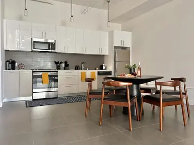 a kitchen with a black table and chairs in it at Luxury 2BR in DTLA w Jacuzzi & Rooftop Views in Los Angeles