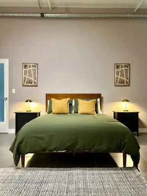 a bedroom with a green bed with two night stands at Luxury 2BR in DTLA w Jacuzzi & Rooftop Views in Los Angeles