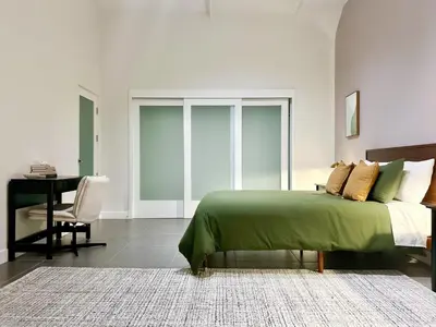 a bedroom with a green bed and a desk at Luxury 2BR in DTLA w Jacuzzi & Rooftop Views in Los Angeles