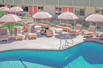 a swimming pool with chairs and umbrellas and a hotel at City Center Hotel By Kasa in Long Beach
