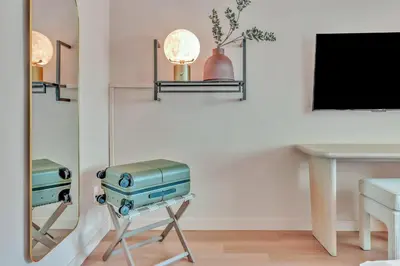 a room with a mirror and a table and a table and a television at City Center Hotel By Kasa in Long Beach