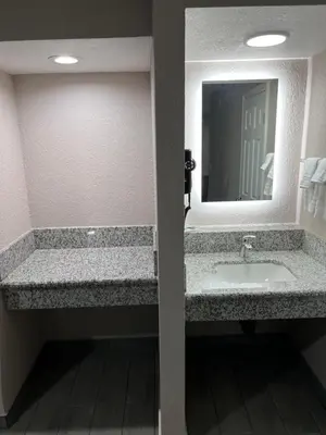 a bathroom with a sink and a mirror at Lone Oak Studio Suites in Bakersfield