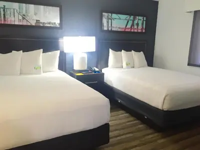 a hotel room with two beds and a lamp at Hyatt House LAX Manhattan Beach in El Segundo