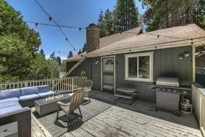 a patio with a couch and a stove on a deck at Cocos Cottage Getaway Running Springs in Running Springs
