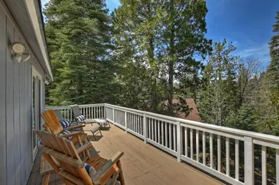 a porch with two chairs and a table on it at Lake Arrowhead Fishermans Haus in Lake Arrowhead