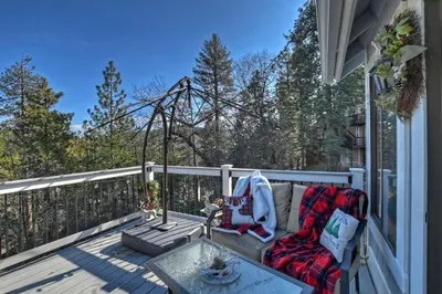a patio with a couch and a table on a deck at Lake Arrowhead Grass Valley Cabin in Lake Arrowhead