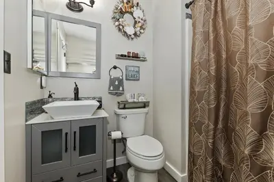 a bathroom with a toilet and a sink and a mirror at Lake Arrowhead Grass Valley Cabin in Lake Arrowhead
