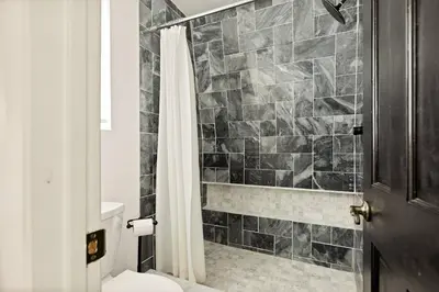 a bathroom with a shower curtain and a toilet at Quiet Mountain Cabin in Lake Arrowhead