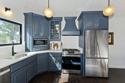 a kitchen with blue cabinets and a stainless steel refrigerator at North Bay Chalet Views in Lake Arrowhead