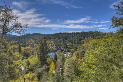 a view of a valley with trees and a lake at North Bay Chalet Views in Lake Arrowhead