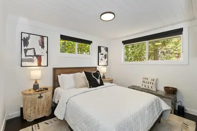 a white bedroom with a bed and two windows at North Bay Chalet Views in Lake Arrowhead