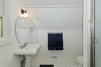 a white bathroom with a sink and a mirror at North Bay Chalet Views in Lake Arrowhead