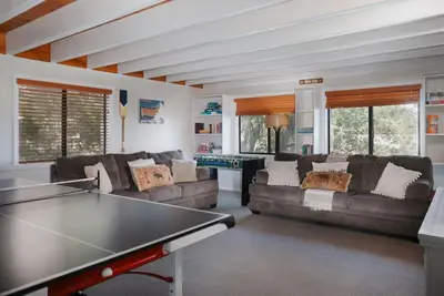 a living room with couches and a ping pong table at Lake Arrowhead Matterhorn Views in Lake Arrowhead