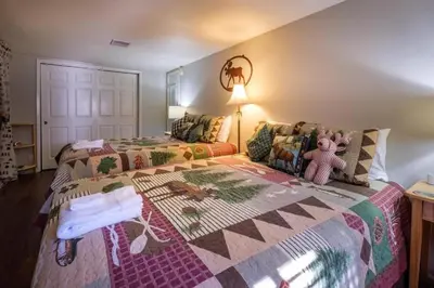 a bedroom with a bed with a quilt on it at The Muddy Moose- Spacious Family Getaway in Lake Arrowhead