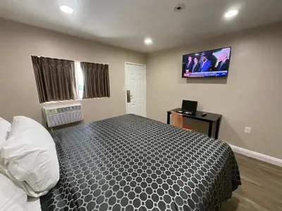 a bedroom with a bed and a flat screen tv at State Motel in South Gate