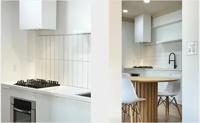 a white kitchen with a table and a stove top oven at Broskin apartments in Los Angeles