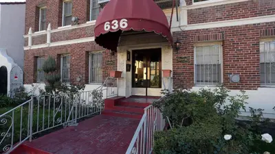 a brick house with a sign on the front door at Broskin apartments in Los Angeles