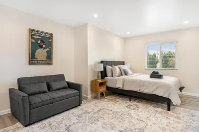 a bedroom with a bed and a couch and a chair at Central Hollywood Apartment in Los Angeles