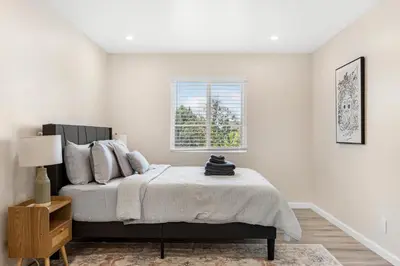 a white bedroom with a bed and a window at Central Hollywood Apartment in Los Angeles