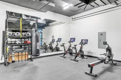 a gym with a bunch of exercise bikes and a punching bag at Blueground Pasadena gym elev near bars LAX-1231 in Los Angeles