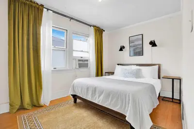 a bedroom with a white bed and a window at Classic Home Near Downtown & Hollywood in Los Angeles