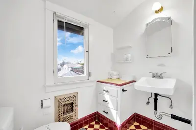 a white bathroom with a sink and a window at Classic Home Near Downtown & Hollywood in Los Angeles
