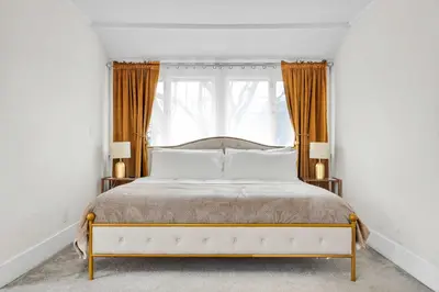 a bedroom with a white bed and a window at Classic Home Near Downtown & Hollywood in Los Angeles