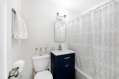 a bathroom with a toilet and a sink and a mirror at Cozy House Minutes From Downtown in Los Angeles